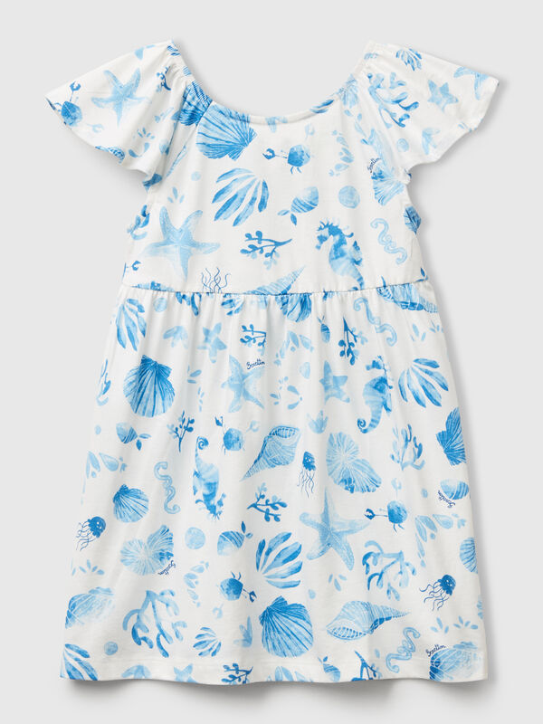 Vestido blanco con conchas azules. Niña