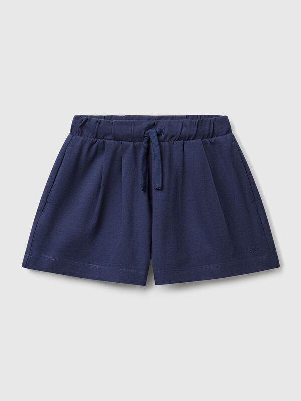 Pantalón corto de puro algodón de tacto cálido. Cintura con cordón, bolsillos insertados en los laterales y logo bordado en el bajo izquierdo. Perfecto para outfits cotidianos. Niña